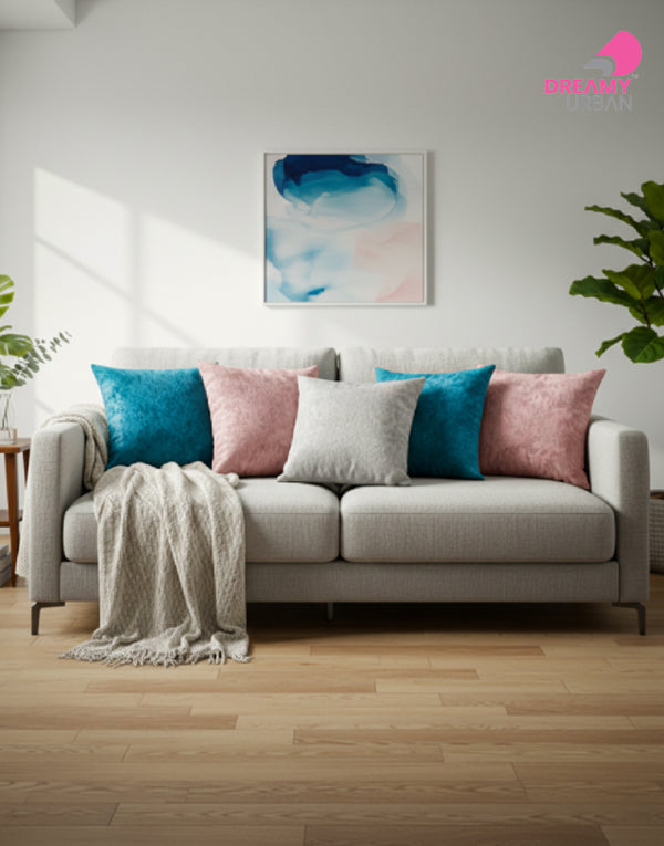 cushion covers in peacock blue, light grey, dusty pink styled on grey sofa with throw blanket